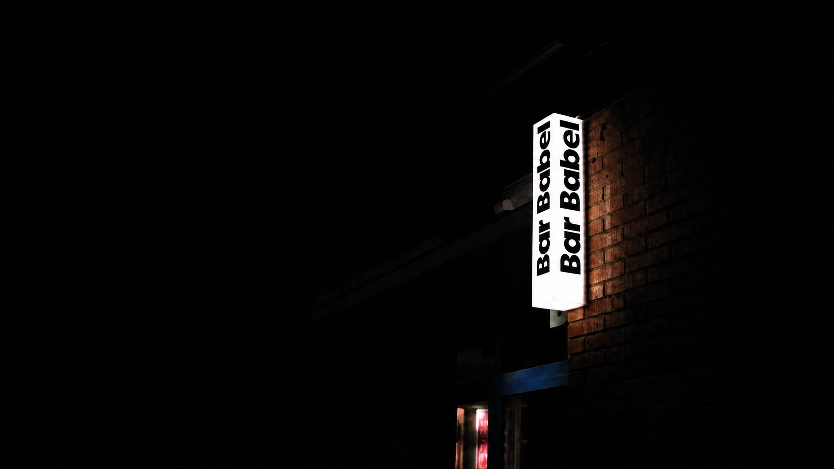 La caja de luz de Bar Babel encendida por la noche