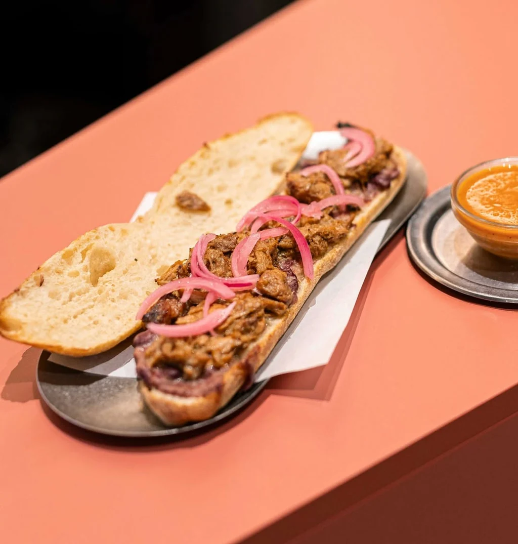 Bocadillo abierto de carne y cebolla encurtida